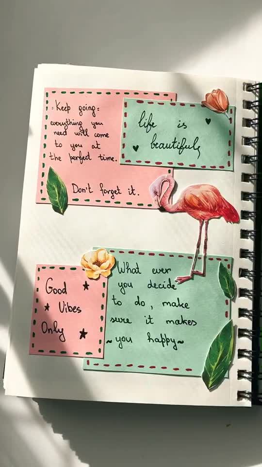 a notebook with two flamingos on it and some words written in different languages next to each other