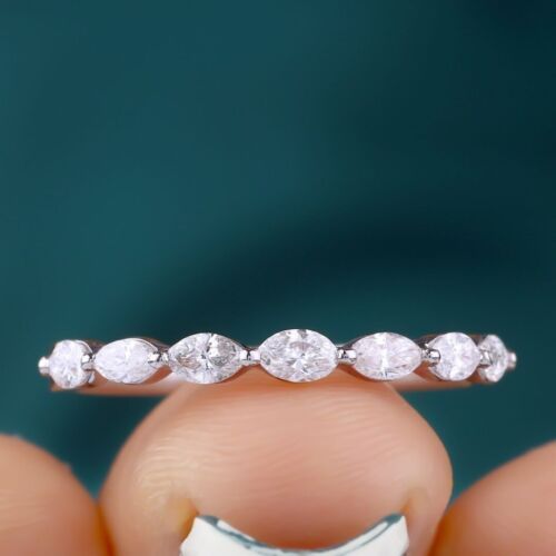 a close up of a person's hand holding a ring with three diamonds on it