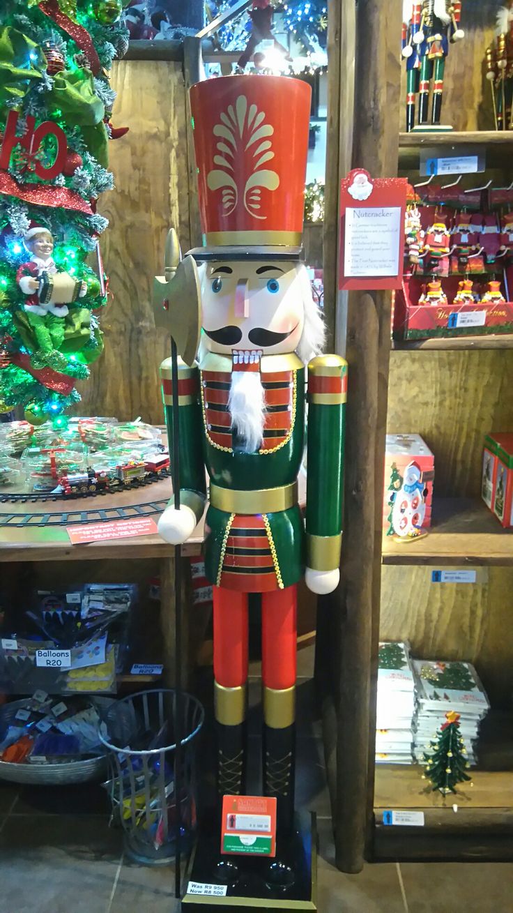 a nutcracker is standing in front of a christmas tree