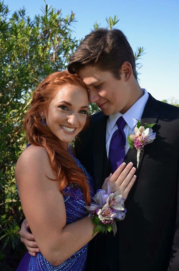 a young man and woman in formal wear embracing each other