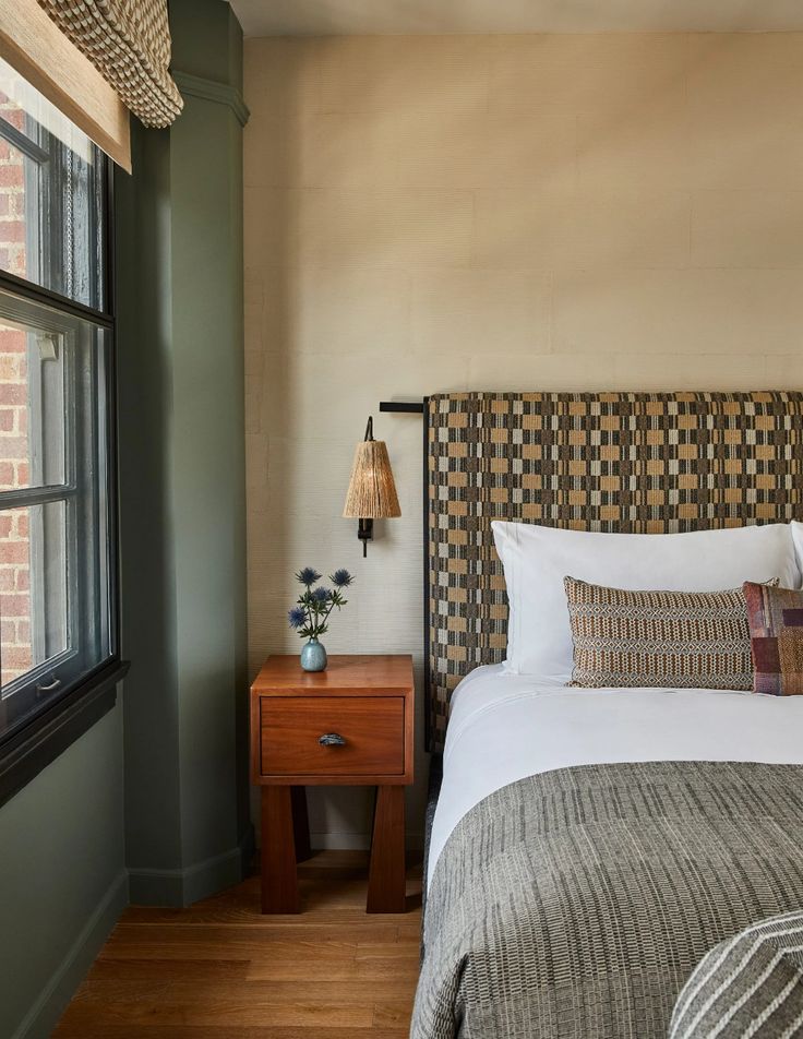 a bed sitting next to a window in a bedroom