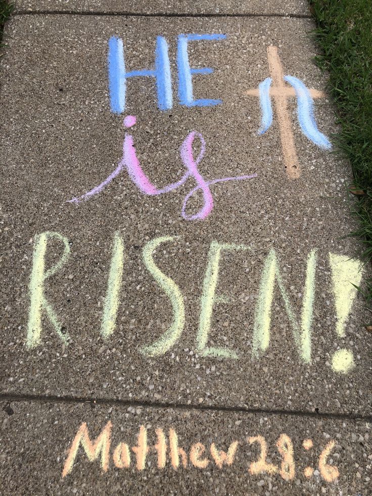 the sidewalk has chalk writing on it that says, he is risen and she is