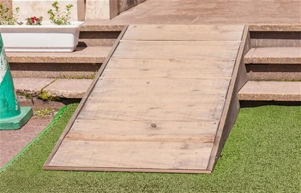 a wooden ramp sitting on top of green grass