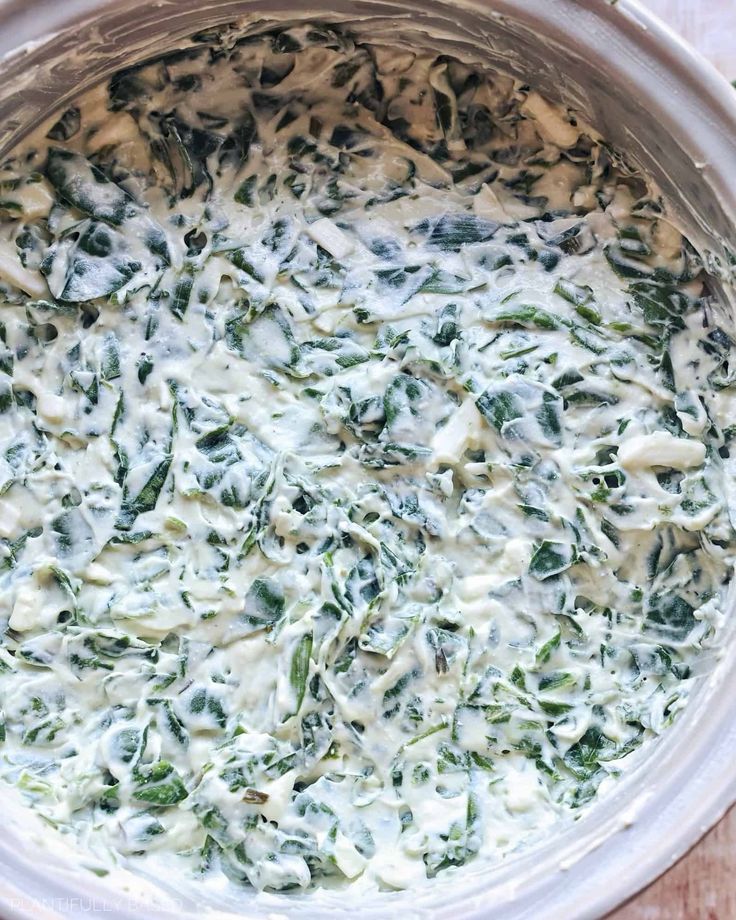 spinach and cheese in a pot on a wooden table