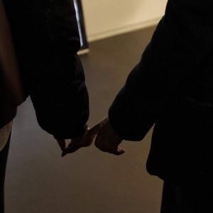 two people are holding hands in the dark