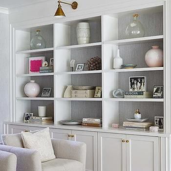 a living room filled with white furniture and lots of bookshelves on top of it