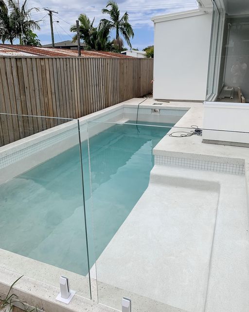 an empty swimming pool with clear glass railings