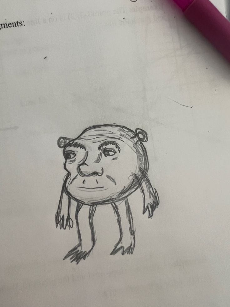 a drawing of a monkey on paper next to a pen