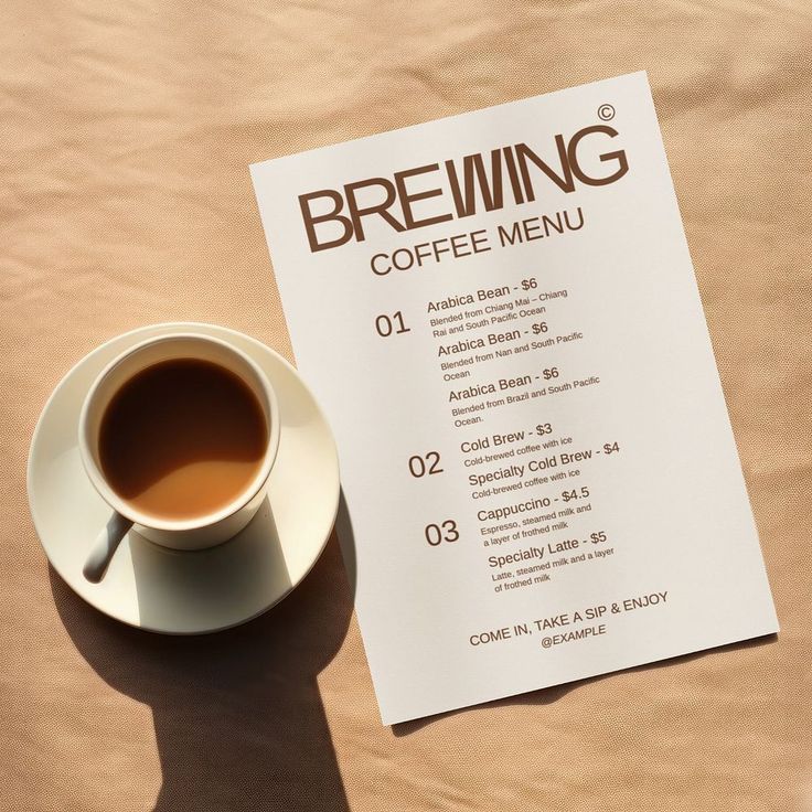 a cup of coffee sitting on top of a table next to a paper with a menu