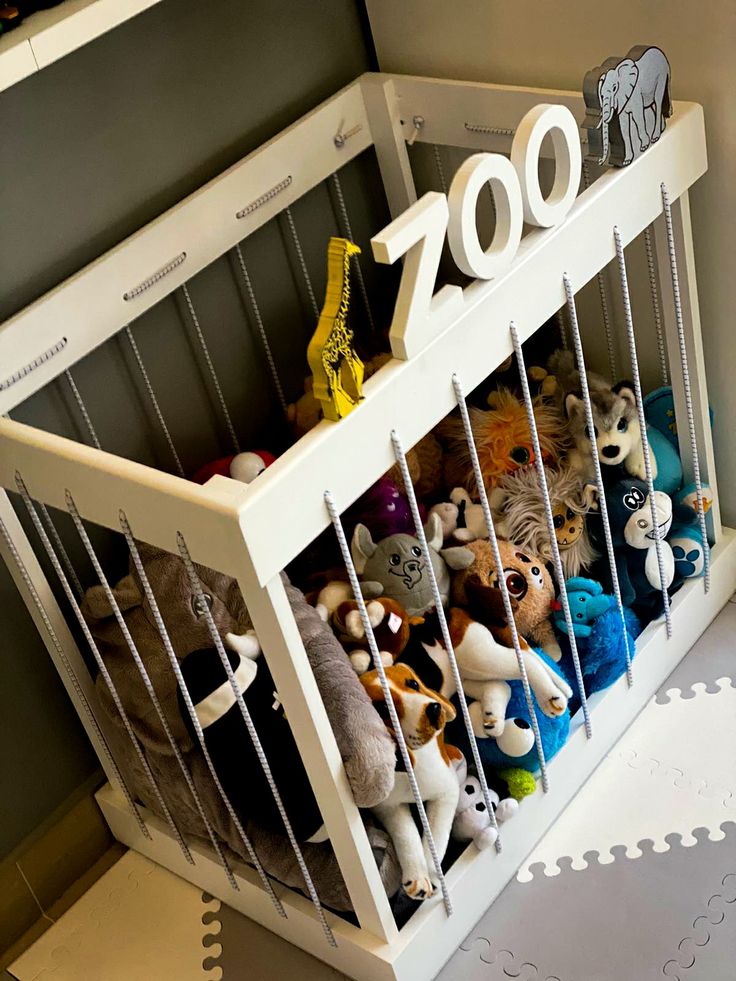 the stuffed animals are in the toy bin on the floor next to the number 20