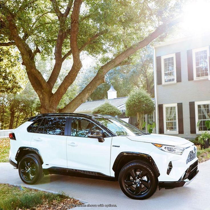 a white suv parked in front of a house