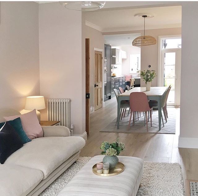 a living room filled with furniture next to a dining room table and chairs on top of a hard wood floor