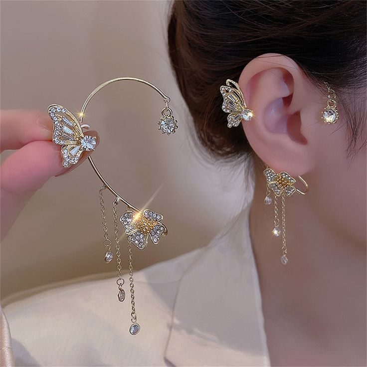 Make a Statement with our Unique Zircon Butterfly Ear Cuff Clip On Earrings Add a touch of elegance and charm to your ensemble with these stunning clip-on earrings. Made with high-quality zinc alloy and adorned with sparkling cubic zirconia crystals, these ear cuffs are designed to stand out and make a statement. Butterfly design for a delicate and feminine look Clip-on style for easy wear without piercings Crafted with shimmering cubic zirconia for a touch of luxury Made with durable and stylis Flower Ear Cuffs, Flower Ear, Gold Ear Cuff, Butterfly Flowers, Butterfly Earrings, Copper Earrings, Ear Jewelry, Piercing Jewelry, Flower Earrings