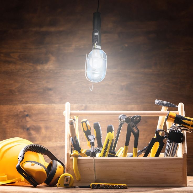 a tool box filled with construction tools under a light bulb