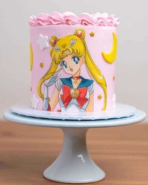 there is a pink cake decorated with sailor moon and stars on the top, as well as an image of princess aurora