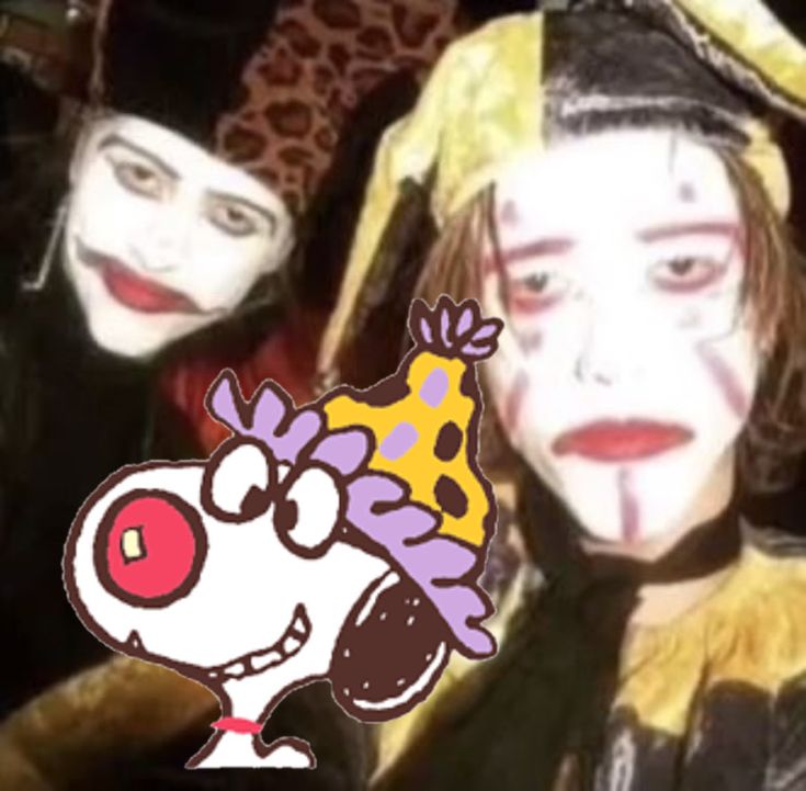 two clowns with painted faces and one has a dog on it's head