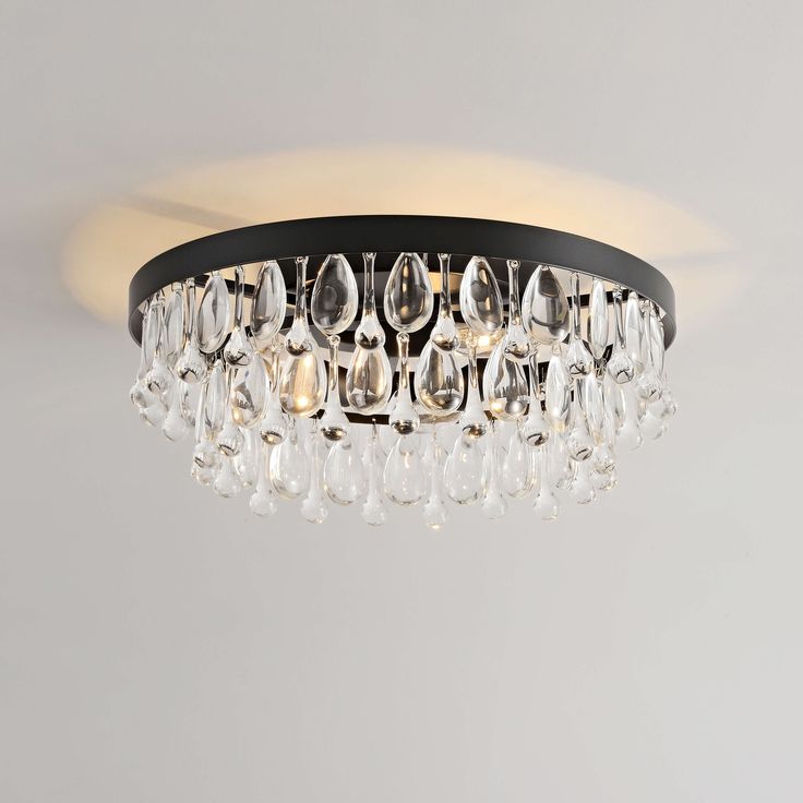 a chandelier hanging from the ceiling with clear crystal drops and black metal frame