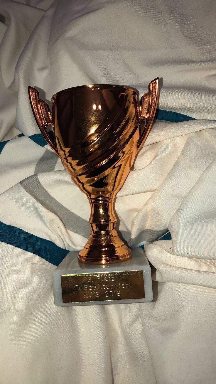 a gold trophy sitting on top of a white blanket