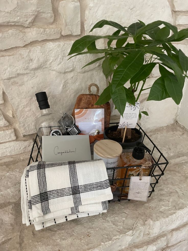 a basket filled with items sitting on top of a stone wall next to a potted plant