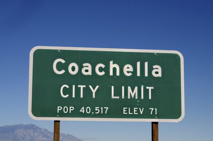 a highway sign for coachella city limit with mountains in the backgrouund