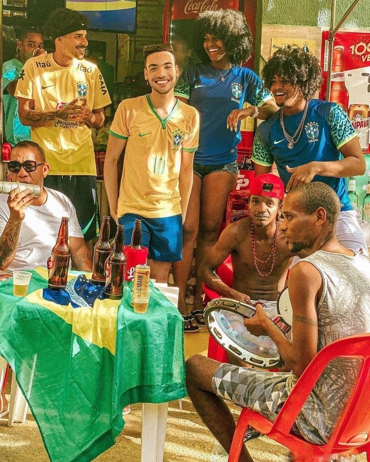 a group of people standing and sitting around a table with drinks on it in front of them