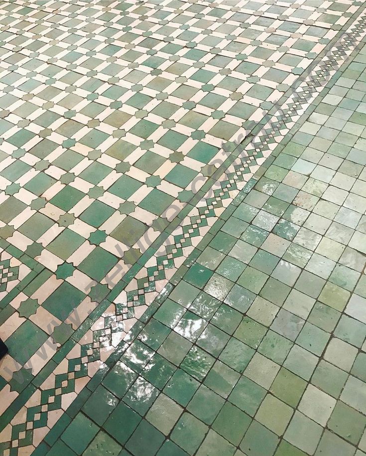 an umbrella sitting on top of a tiled floor next to a black and white dog