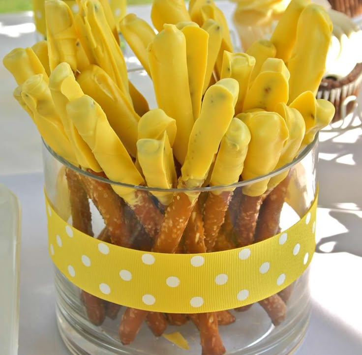 a glass bowl filled with yellow candy sticks