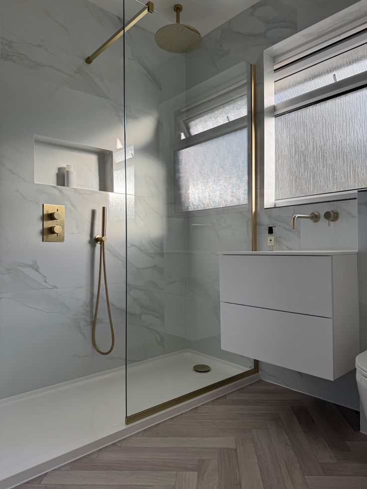 a bathroom with a toilet, sink and shower in it's own area next to a window