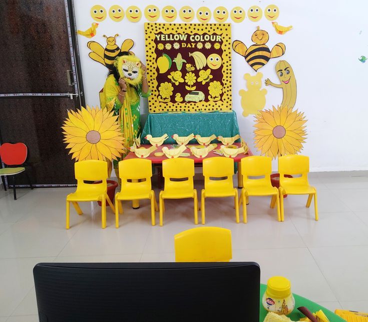 there are many yellow chairs and tables in this room with decorations on the wall behind them