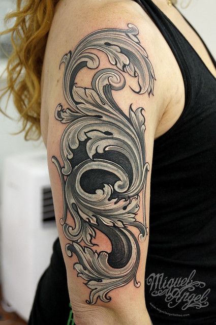 a woman with a black and grey tattoo on her arm