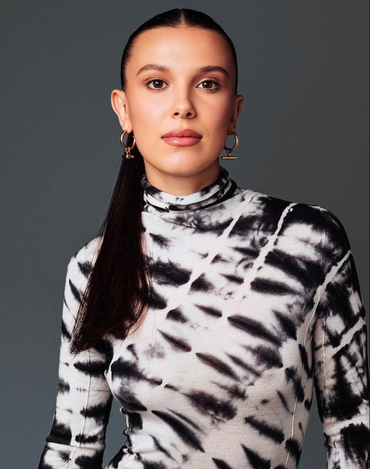 a woman with long hair wearing a black and white tie dye top