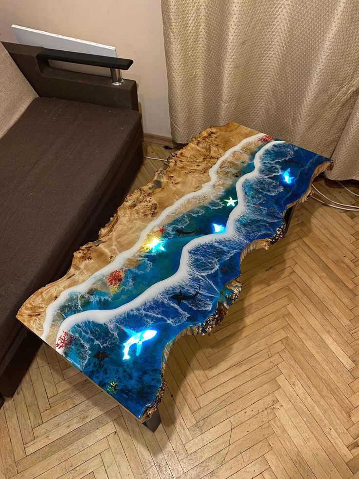 a table that is made to look like an ocean wave with lights on it, sitting on a wooden floor