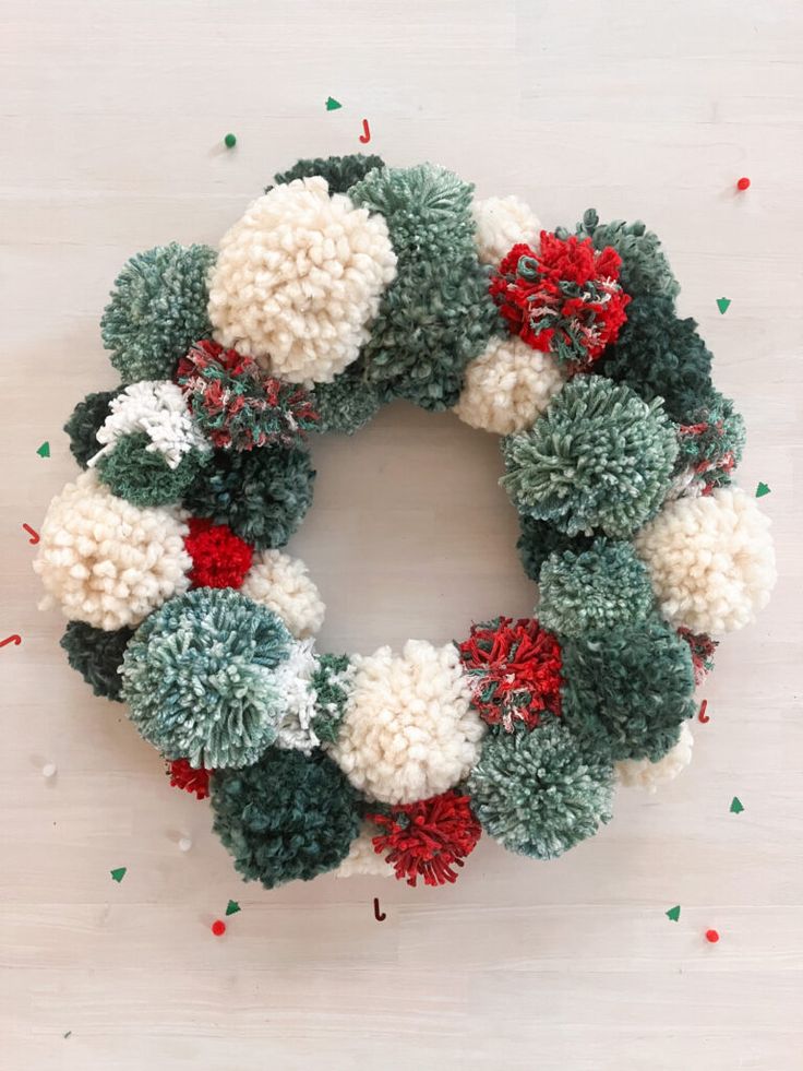 a christmas wreath made out of pom - poms on top of a table