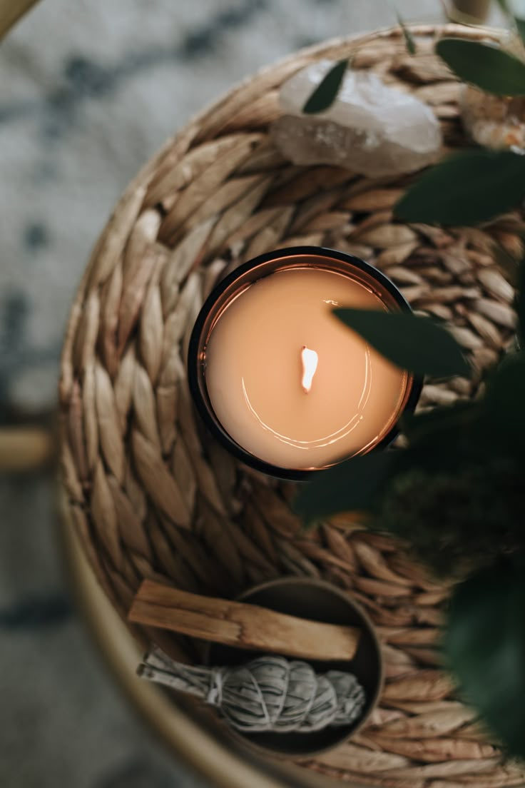 a lit candle sitting on top of a wicker basket