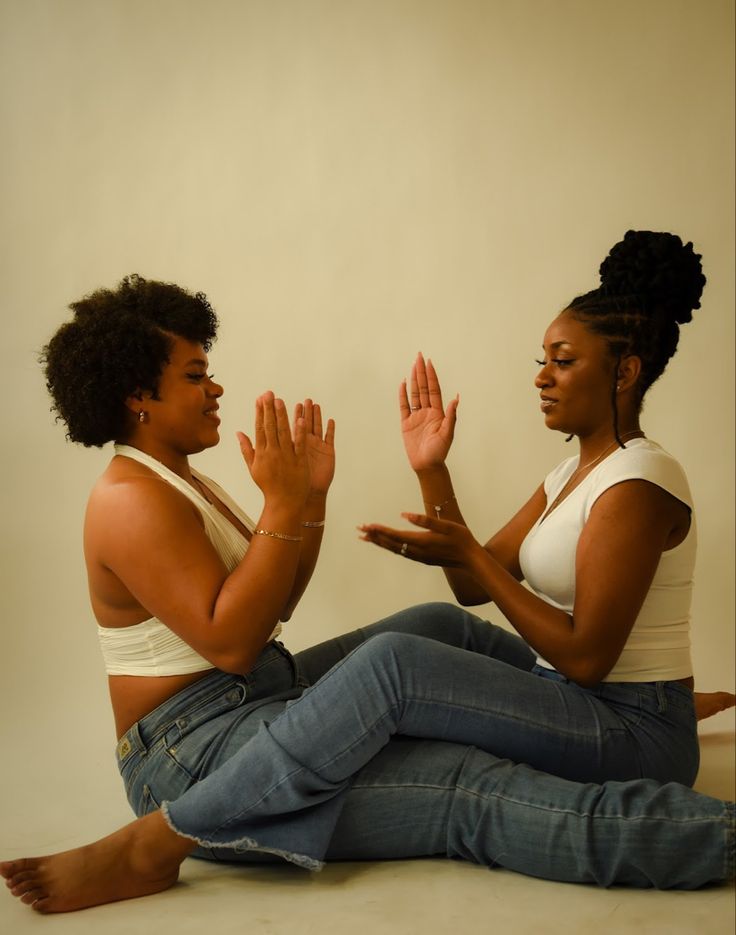 two women sitting on the floor and clapping