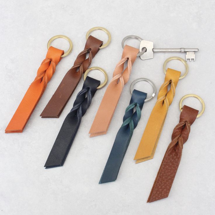 six different colored ties are tied together with metal rings and keychains on a white surface