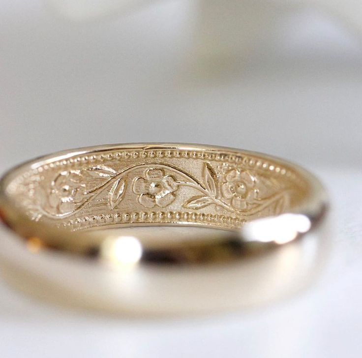 a gold wedding ring sitting on top of a table