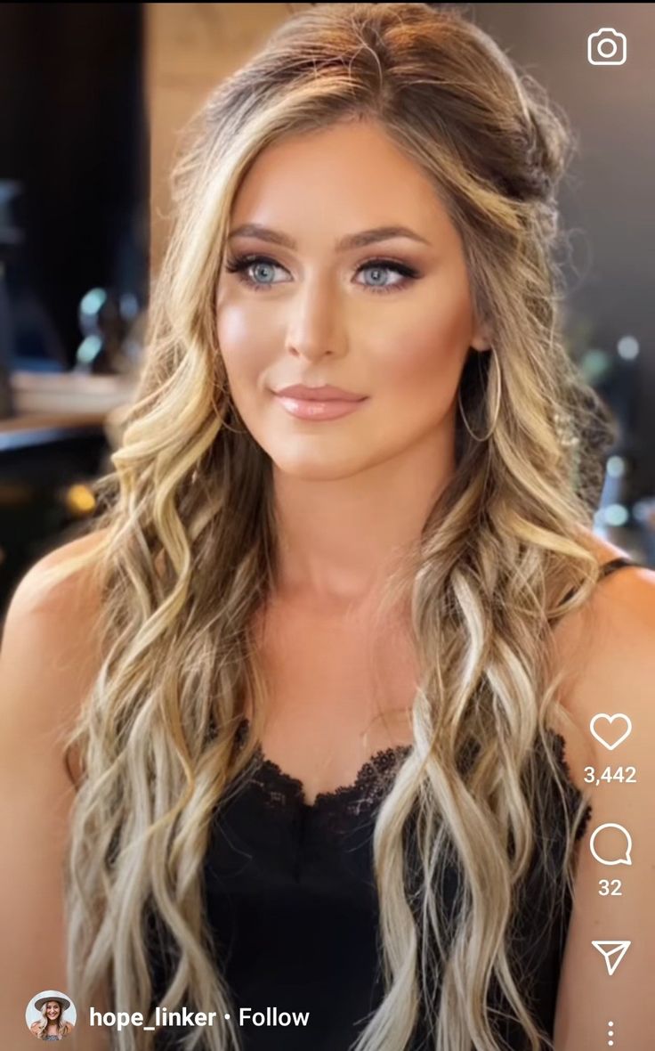 a woman with long blonde hair and blue eyes is looking at the camera while wearing a black top