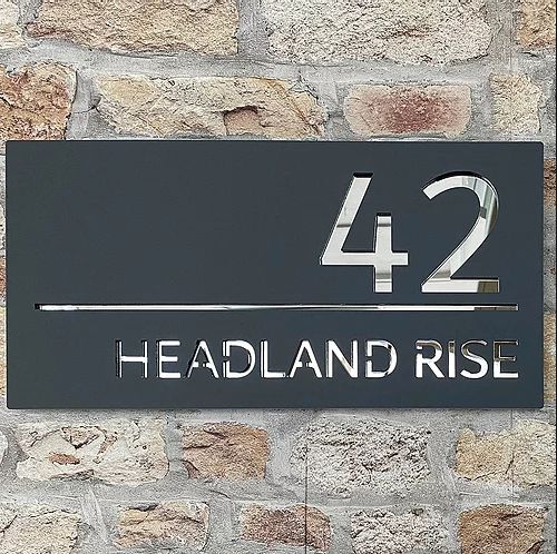 a metal sign that reads headland rise on a brick wall with the number 42