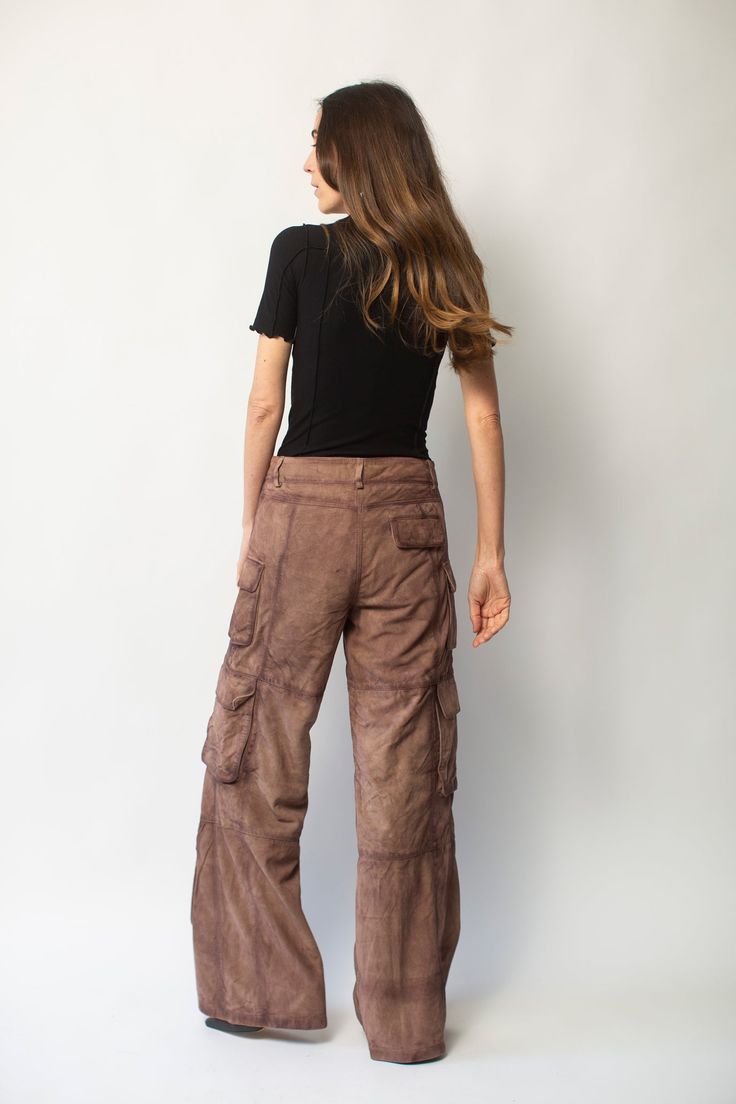 Deadwood's workwear-inspired cargo suede pants with wide flowing silhouette feature side pockets and multiple cargo pockets on the legs with a hidden push button closing. Made from upcycled deadstock goat suede Relaxed wide fit Zip fly Lining fabric from 100% recycled plastic bottles Brown Utility Parachute Pants For Fall, Utility Brown Bottoms With Multiple Pockets, Utility Leather Pants With Multiple Pockets, Utility Style Straight Leg Leather Pants With Pockets, Wide Leg Leather Pants With Cargo Pockets For Fall, Brown Utility Bottoms With Multiple Pockets, Brown Pants With Flap Pockets For Fall, Brown Bottoms With Flap Pockets For Fall, Fall Parachute Pants With Multiple Pockets And Loose Fit