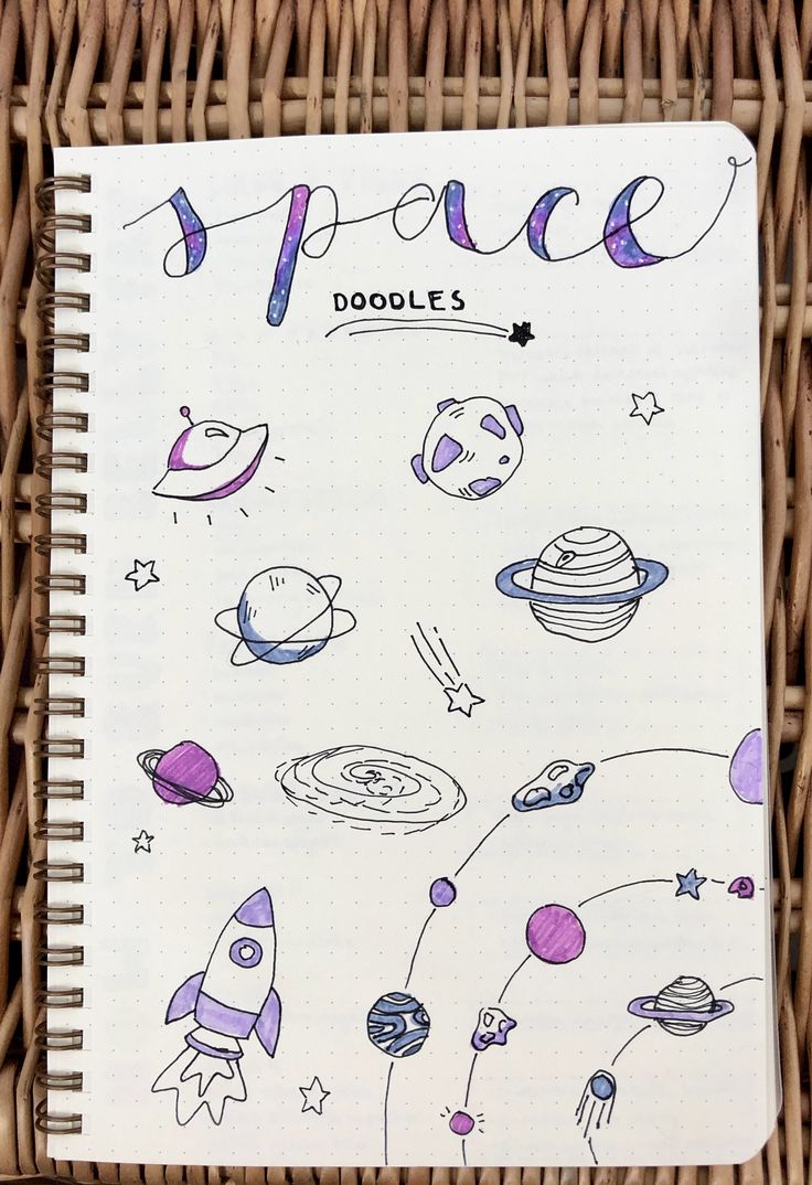 an open notebook with space doodles on it