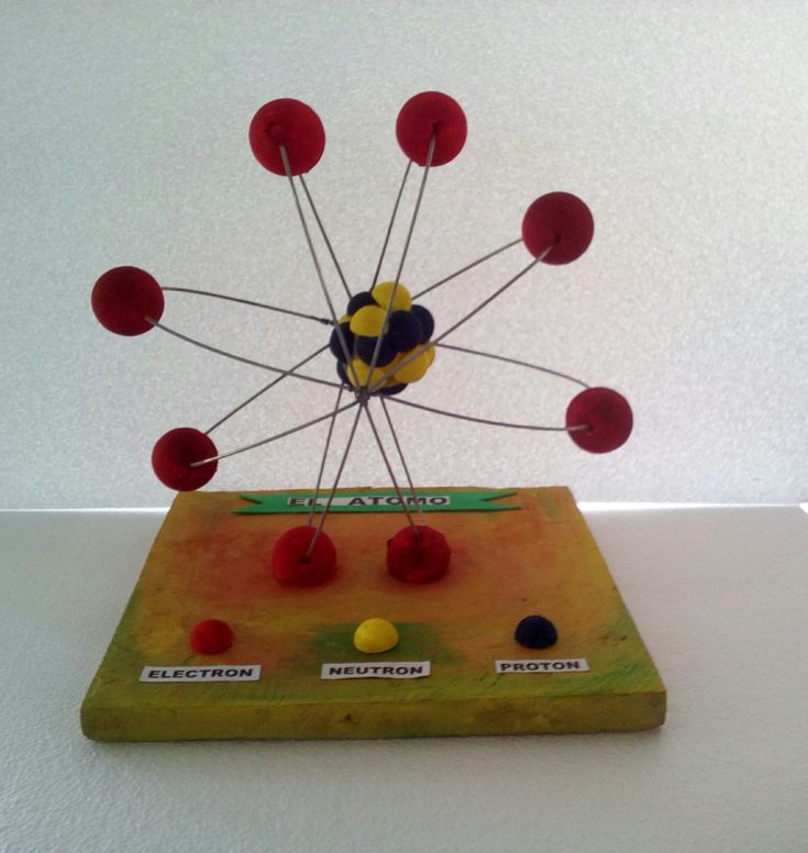 a wooden board with pins and magnets attached to it on top of a table