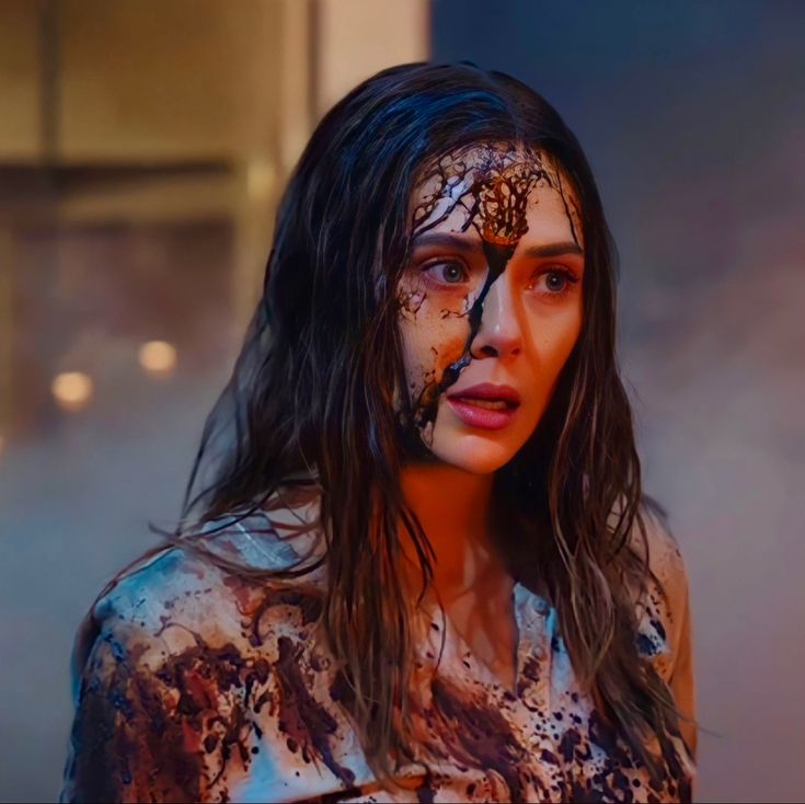 a woman is covered in mud and paint