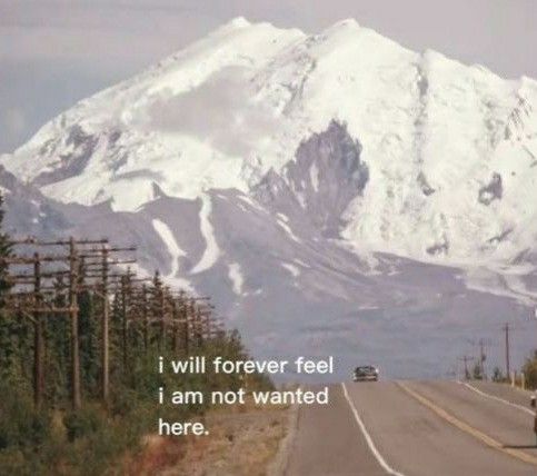 a car driving down the road in front of a snow covered mountain with a quote written on it