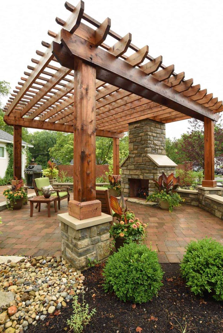 an outdoor patio with stone and wood pergoline, seating area and fire pit