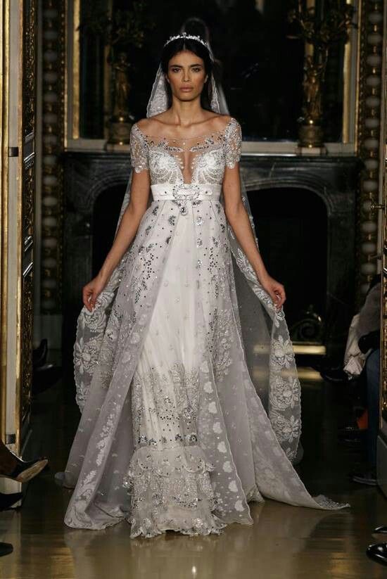 a model walks down the runway wearing a wedding dress with an open back and long veil