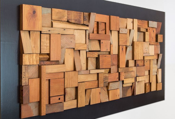 a wooden wall hanging on the side of a white wall