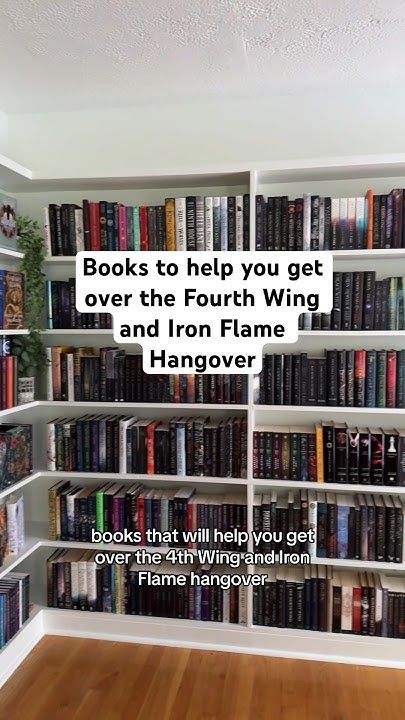 a book shelf filled with lots of books on top of wooden flooring next to a white wall