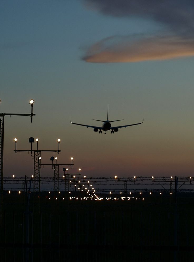 an airplane taking off from the runway at night with its landing gear down and lights on