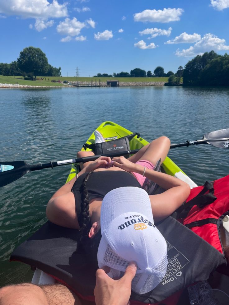 two people in kayaks paddling on the water with their feet propped up against each other